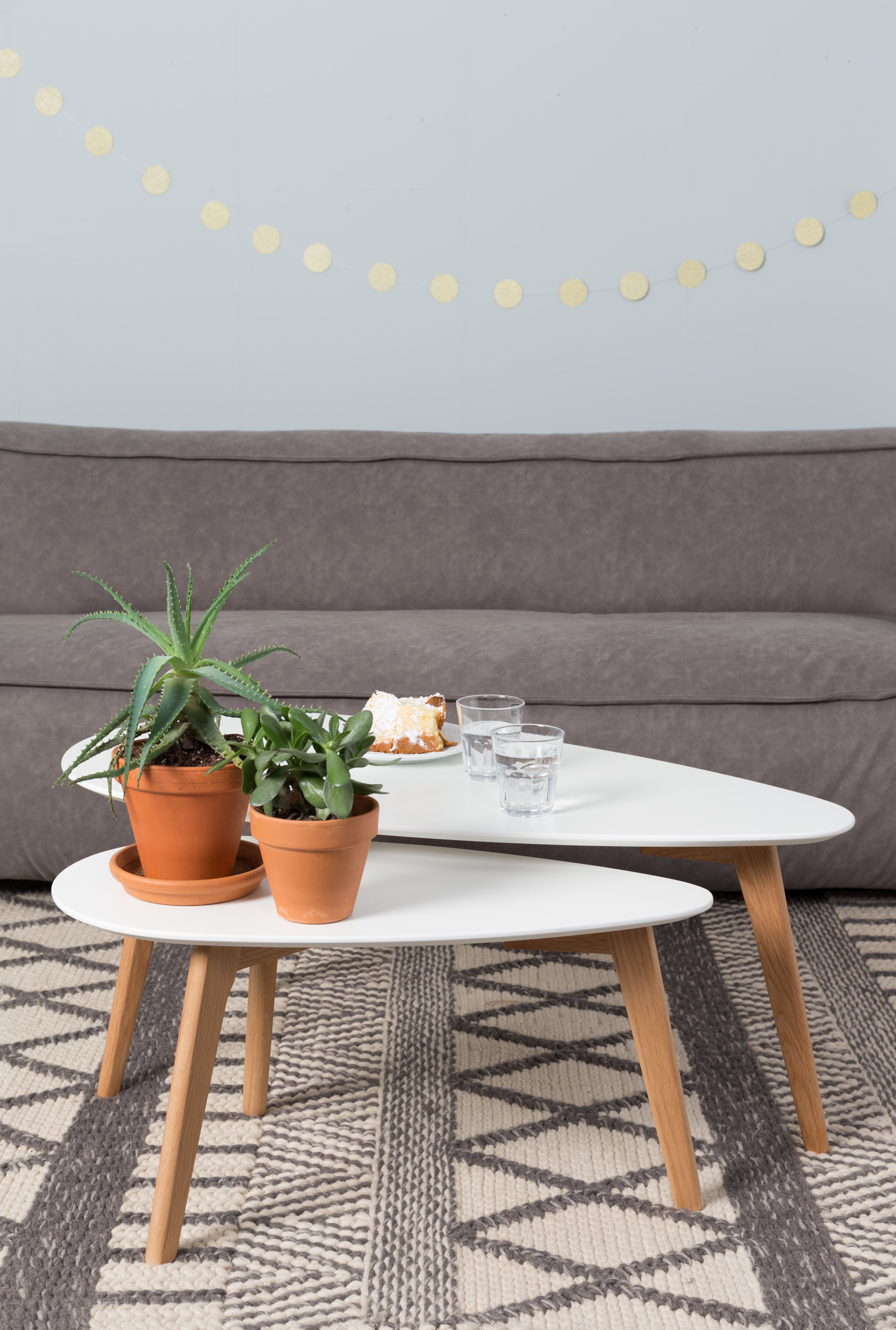 A set of white drop tables with a wooden base