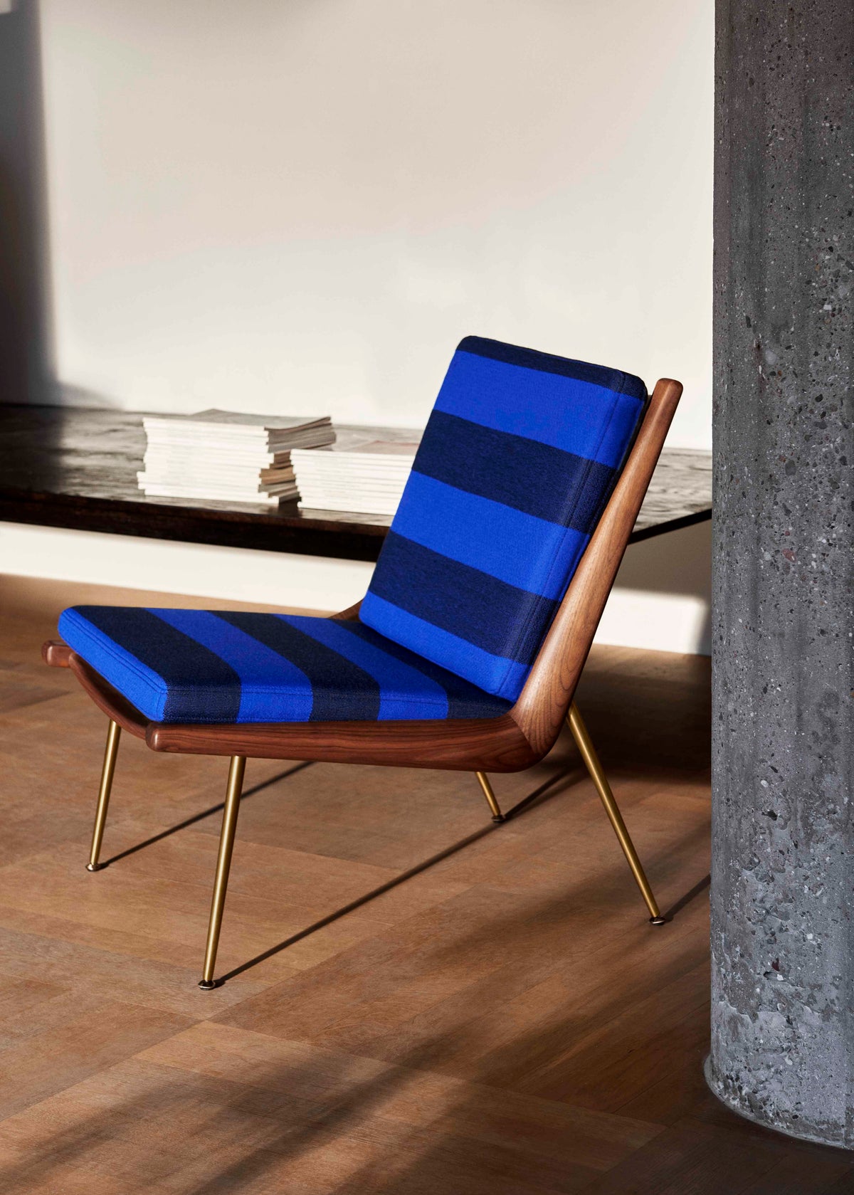 Fotel BOOMERANG HM1 met een notenhouten frame en een stalen basis