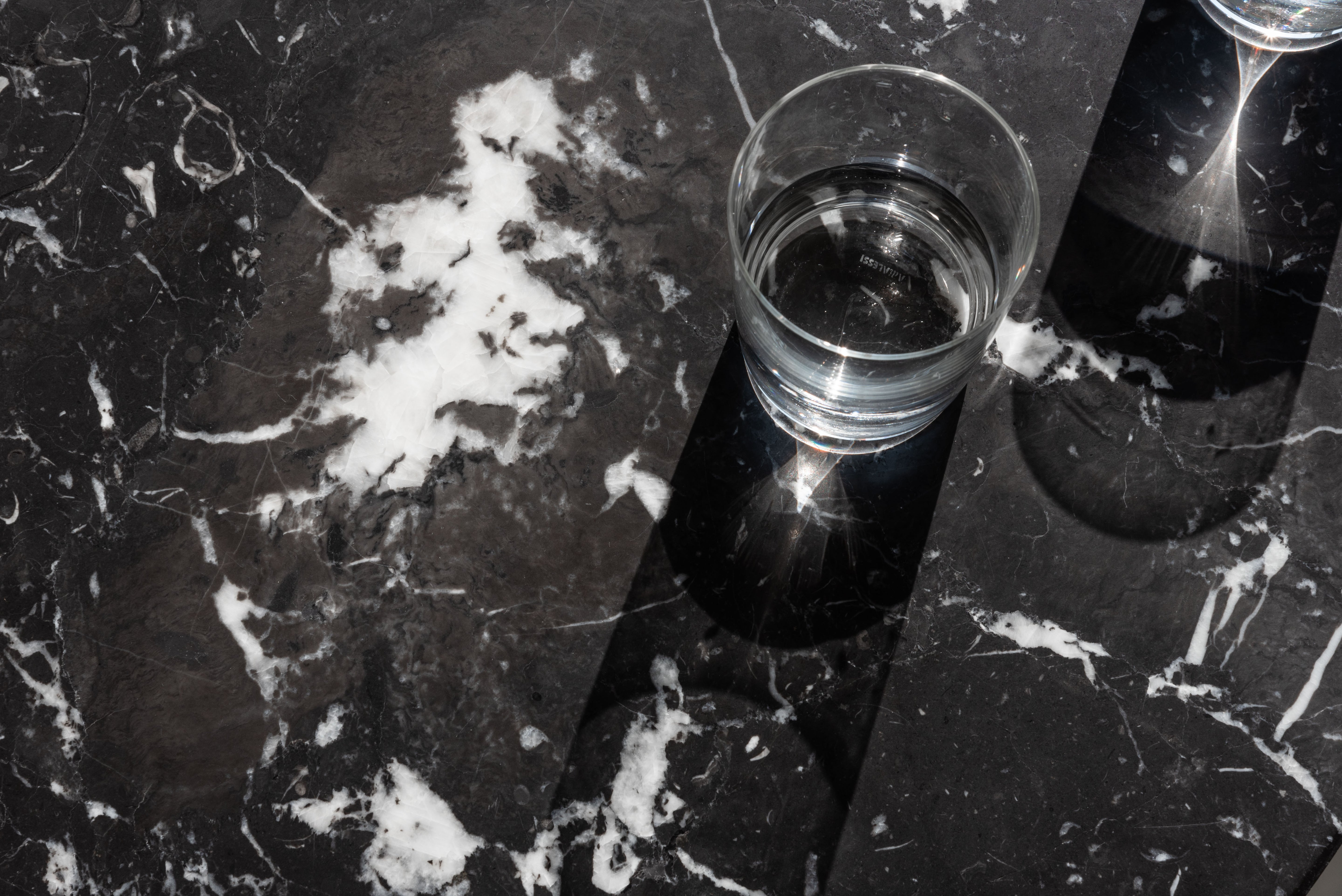 BRUT runder Tisch aus schwarzem Marmor mit schwarzem Sockel