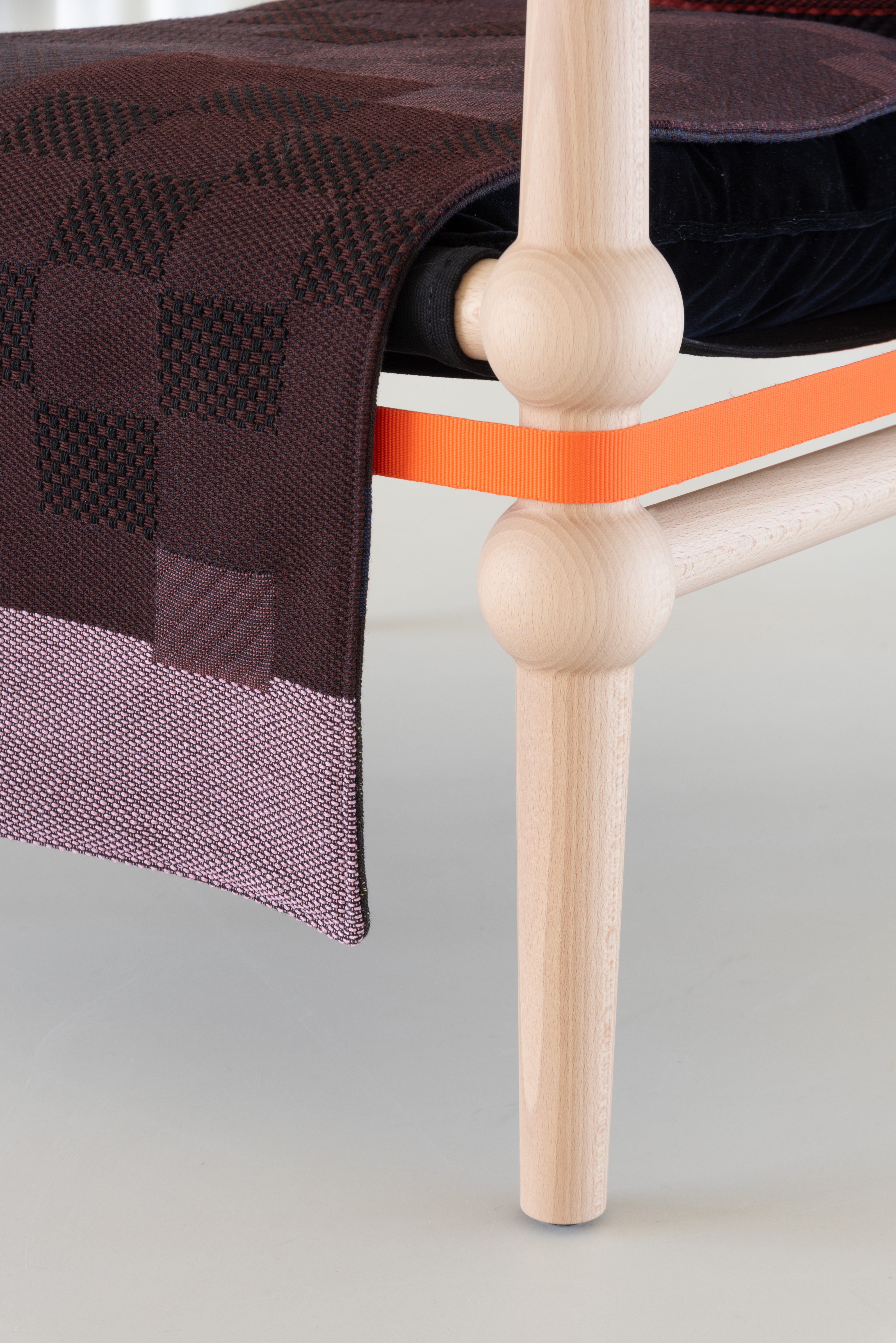 TWAIN armchair with a brown-purple blanket and a light beech base