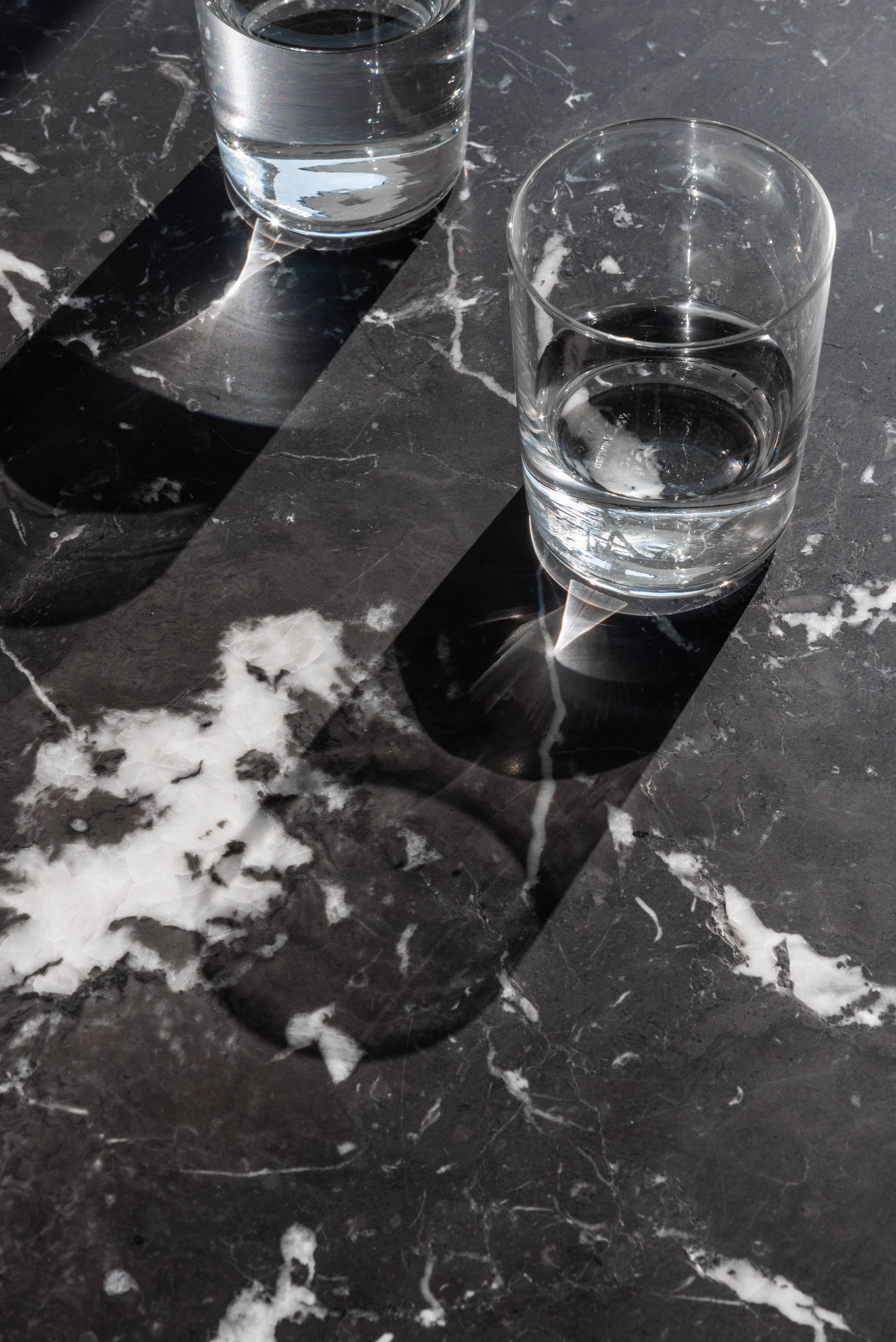 BRUT runder Tisch aus schwarzem Marmor mit schwarzem Sockel