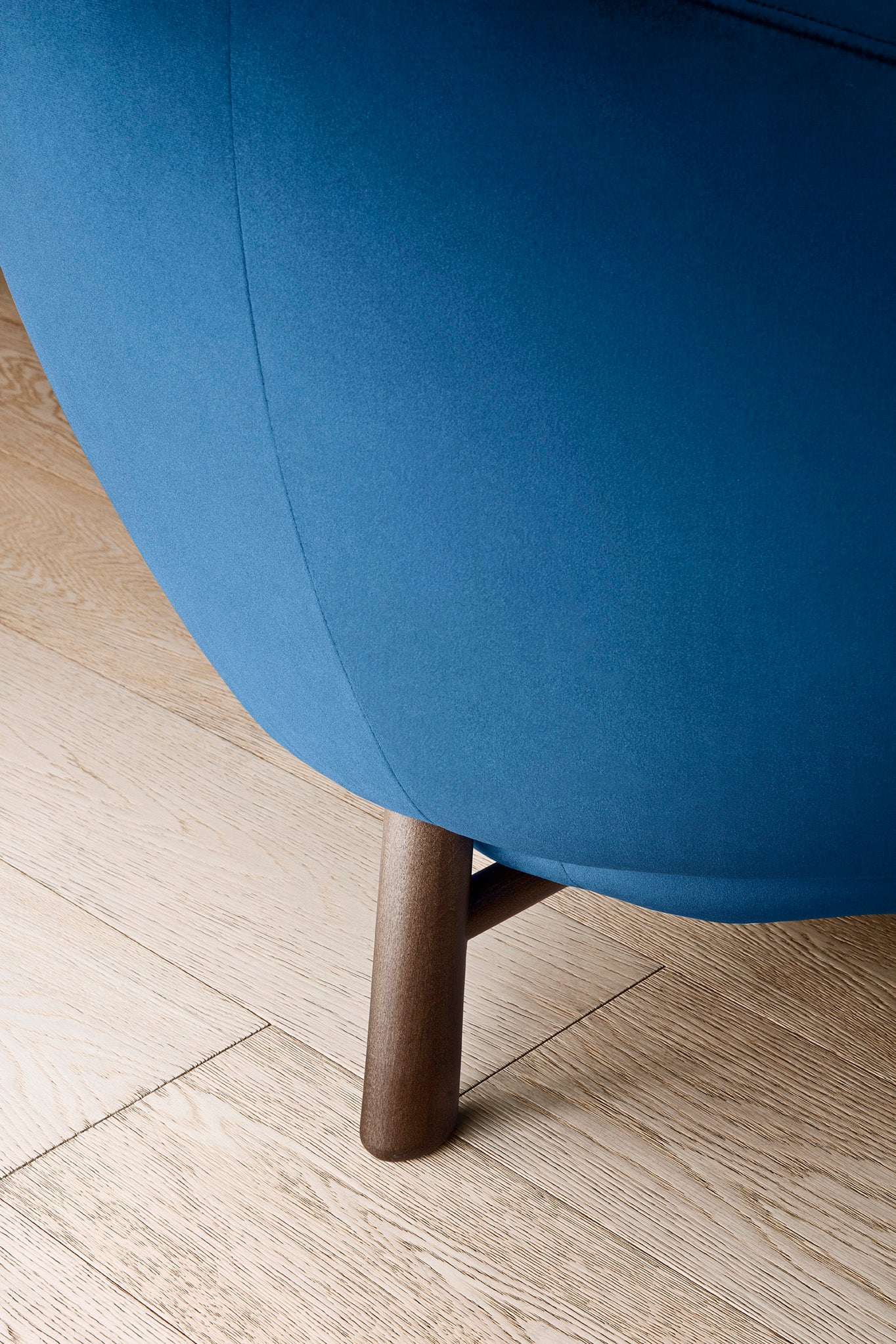 Upholstered RIO armchair with a dark wooden base