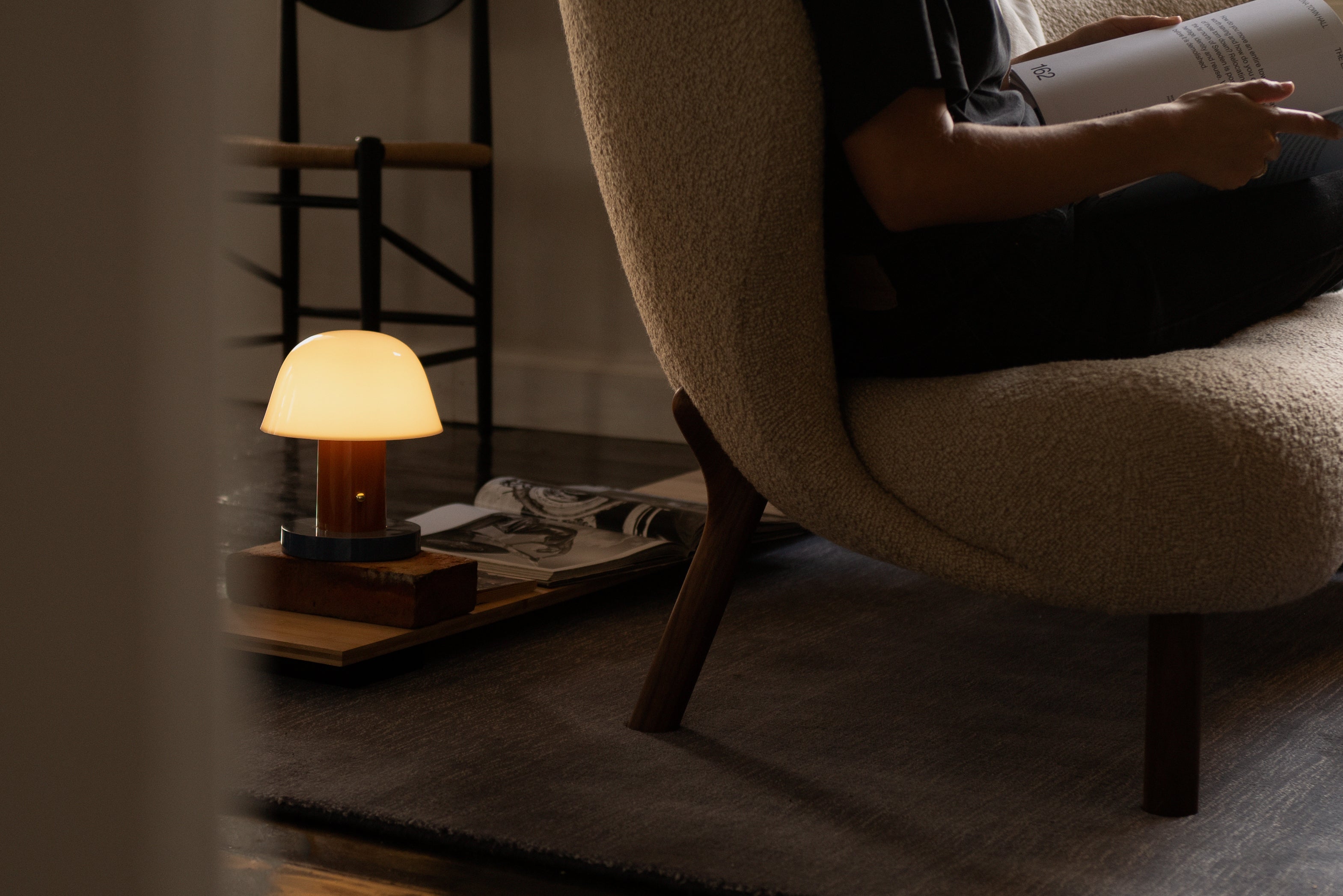 Draagbare lamp SETAGO JH27 met een crèmekleurige kap en een oranje-blauwe voet.