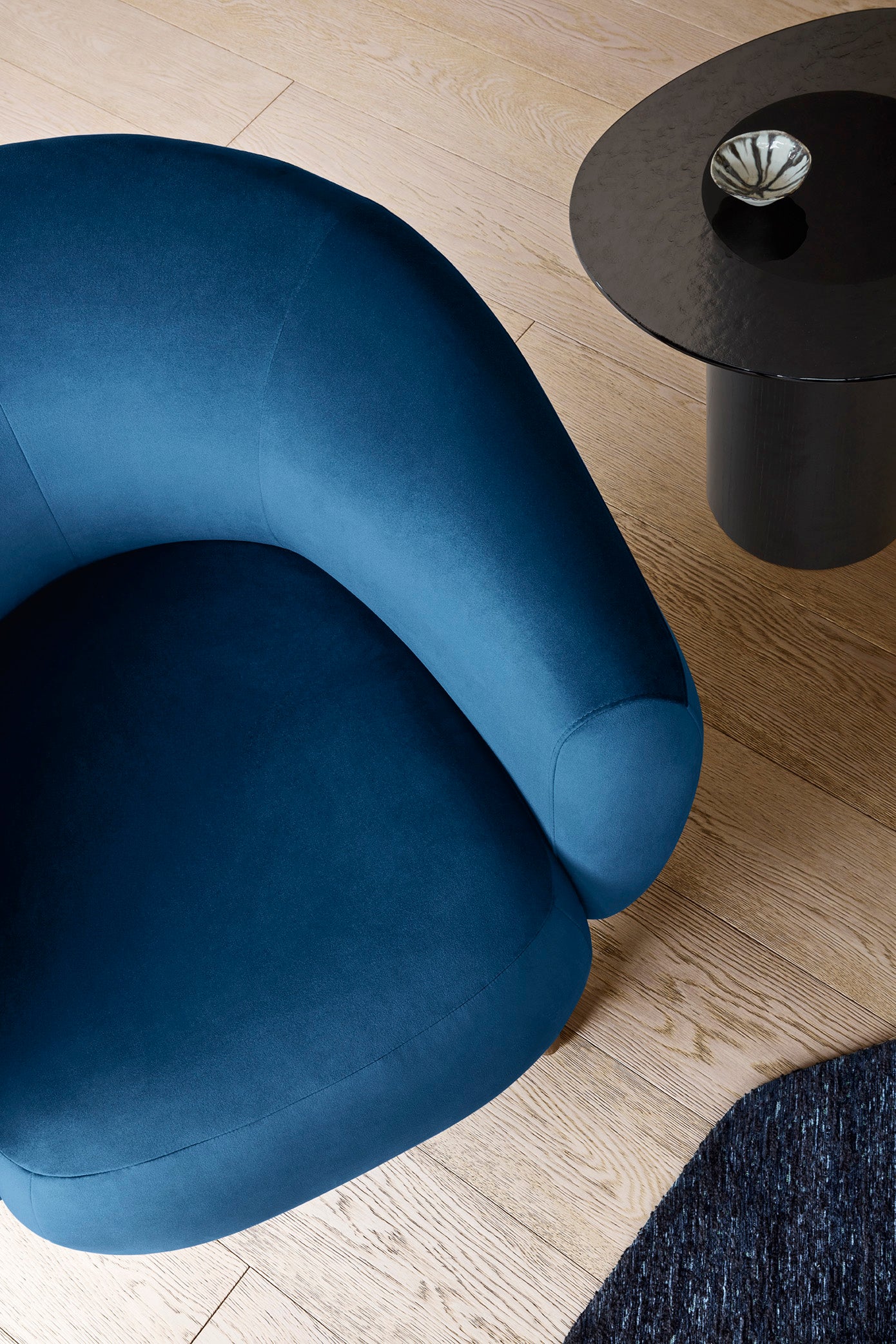 Upholstered RIO armchair with a dark wooden base