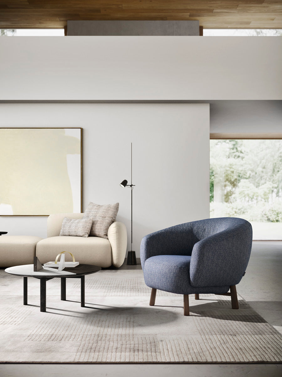 Upholstered RIO armchair with a dark wooden base