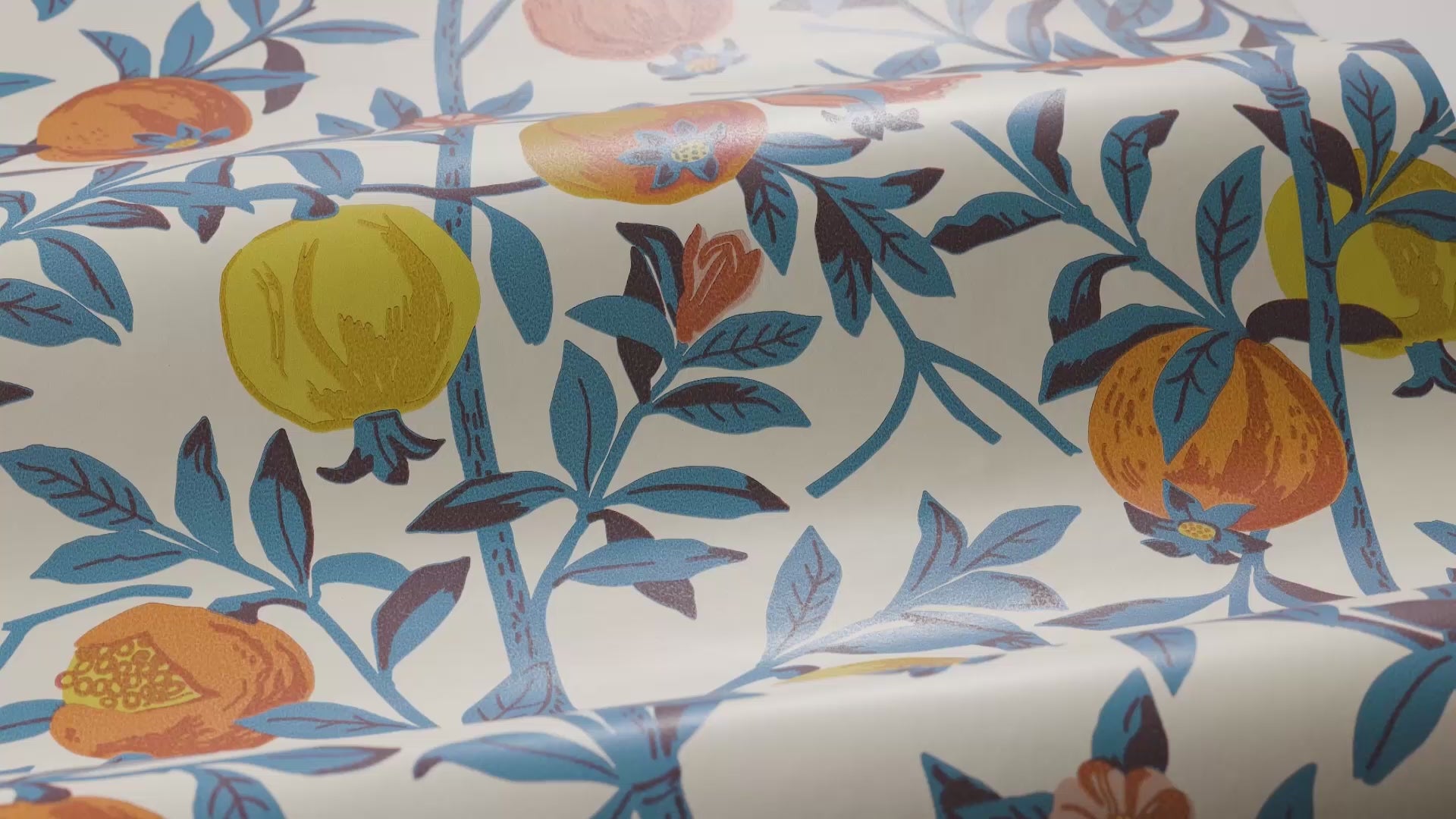 Wallpaper with a botanical pattern of pomegranates in white with blue and orange